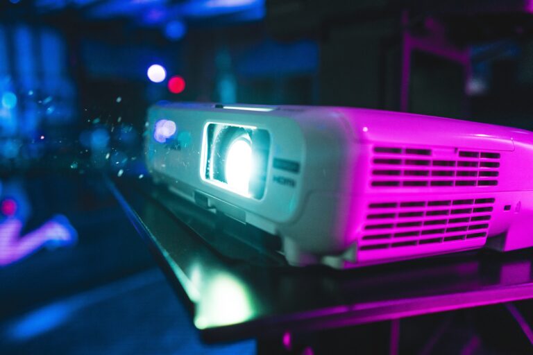 A closeup of a projector under the colorful lights with a blurry background